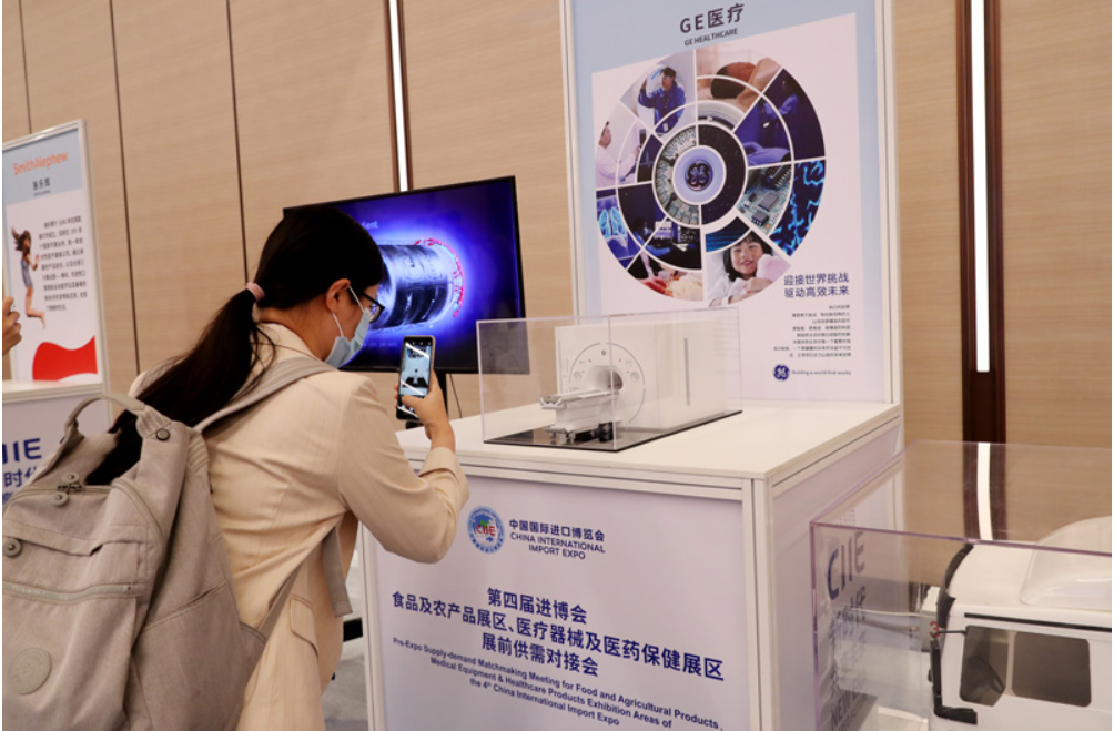 第四屆進(jìn)博會食品及農(nóng)產(chǎn)品展區(qū)、醫(yī)療器械及醫(yī)藥保健展區(qū)展前供需對接會的參會嘉賓用手機(jī)拍攝參展企業(yè)的展品模型